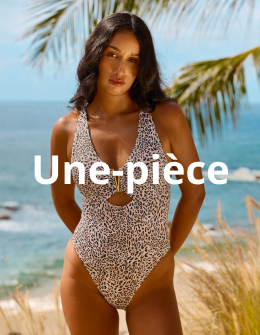 Femme sous un arbre posant les mains derri&egrave;re le dos et portant un maillot une-pi&egrave;ce l&eacute;opard de la marque Santemare.